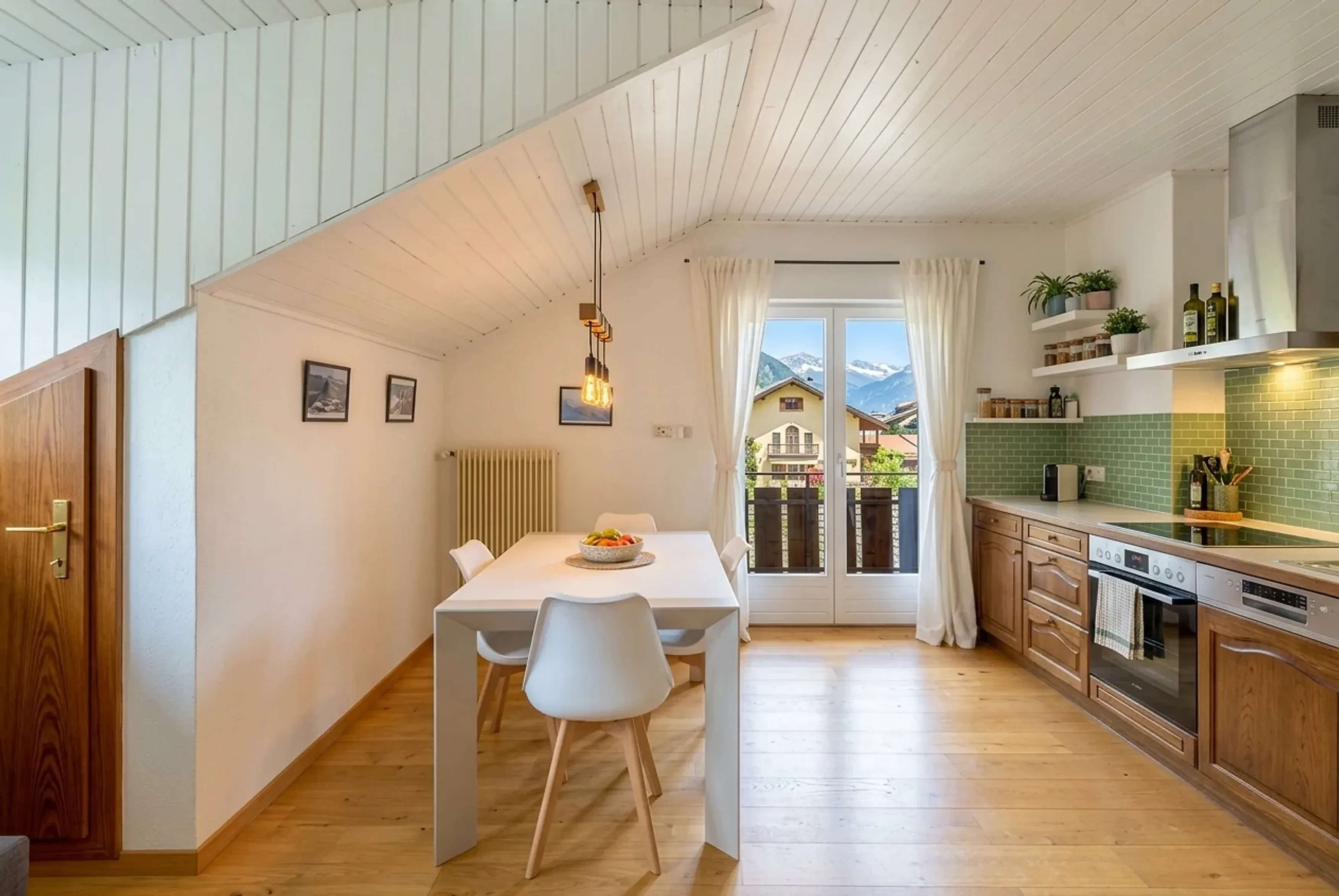 Cucina con tavolo e portafinestra sul balcone in un appartamento a Brunico