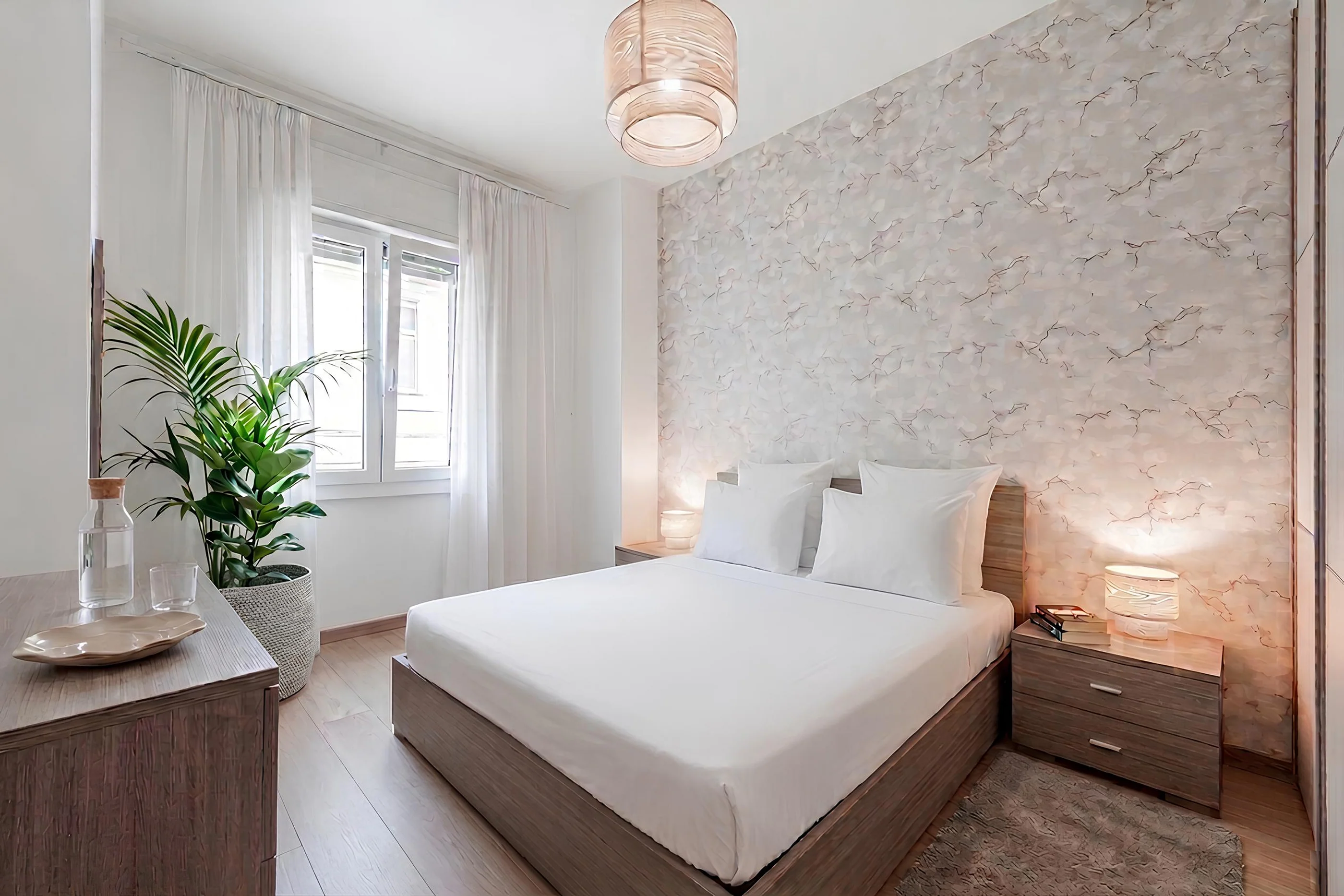 Camera da letto con letto matrimoniale, parete decorata e lampade accese, in un appartamento a Trieste